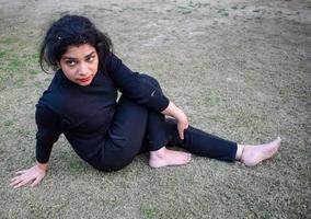 jeune femme indienne pratiquant le yoga en plein air dans un parc. belle fille pratique la pose de yoga de base. calme et détente, bonheur féminin. poses de yoga de base en plein air photo