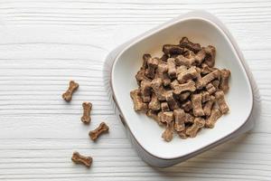 un bol de nourriture pour chien sur un plancher en bois. photo