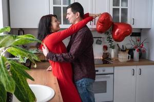 homme et femme amoureux date à la maison dans la cuisine câlins heureux. saint valentin, couple heureux, histoire d'amour. nid d'amour, logement pour jeune famille photo