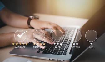 main utilisant un ordinateur portable avec le concept d'enquête sur les commentaires de satisfaction des clients, l'utilisateur attribue une note à l'expérience de service sur l'application en ligne, service menant à une entreprise de classement de réputation, 5 étoiles photo