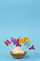 cupcake aux bougies de couleur arc-en-ciel pour un anniversaire avec l'inscription joyeux anniversaire photo
