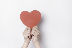 une photo d'un papier en forme de coeur rouge isolé sur fond blanc.