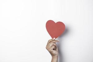 une photo d'un papier en forme de coeur rouge isolé sur fond blanc.