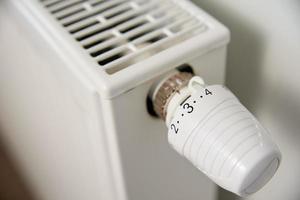 Tourner à la main le thermostat du bouton du radiateur de chaleur photo