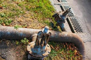 vieux robinet d'eau rouillé sur le fond et les tubes d'approvisionnement en eau. photo