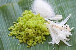 riz vert sucré, dessert thaï - riz non mûr pilé nourriture flocons de riz céréales avec noix de coco et sucre, dessert alimentaire ou collations - nom khao mao en thaïlande photo