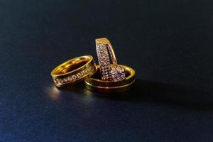anneaux de mariage en or avec des diamants fond noir isolé photo