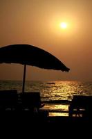 plage au coucher du soleil avec un abri parapluie photo