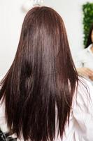 belle jeune femme aux longs cheveux noirs dans un salon de beauté. photo