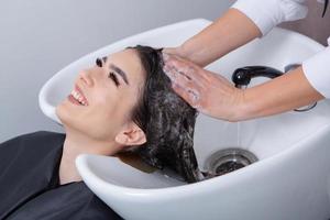 coiffeur professionnel laver les cheveux de la jeune femme dans un salon de beauté. gros plan des cheveux de la femme dans un salon de beauté, concept de coiffure photo