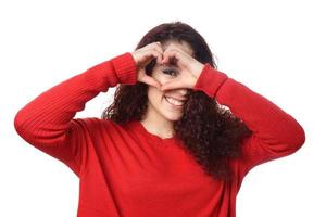 fille regardant à travers le signe de la main en forme de coeur photo