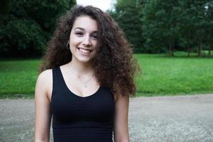 belle jeune femme brune aux longs cheveux bouclés dans la nature photo