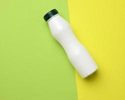 bouteille en plastique blanc pour le lait sur fond vert, récipient pour produits liquides photo