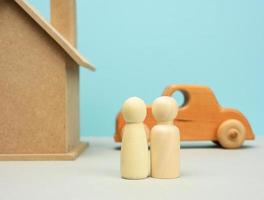 maison en bois et voiture avec figurines familiales miniatures, concept d'hypothèque et de prêt photo