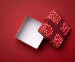 boîte carrée rouge vide sur fond rouge, cadeau ouvert photo