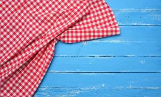 serviette de cuisine en coton rouge et blanc pliée sur un fond bleu en bois photo