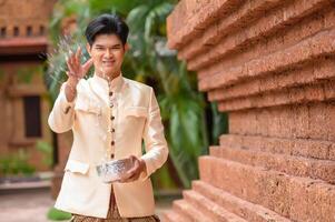 jeune homme éclaboussant de l'eau du bol sur le festival de songkran photo
