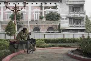 homme asiatique assis dans un parc, semarang, java central, indonésie. photo