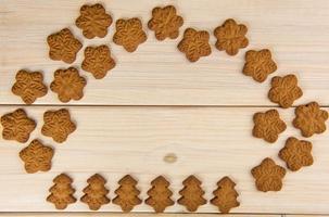 Biscuits de pain d'épice en forme de flocon de neige sur table en bois photo