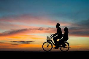 silhouette de jeune couple ensemble pendant le coucher du soleil photo