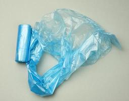 sacs en plastique bleu torsadé pour poubelle sur fond gris photo