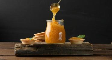 caviar de brochet salé dans un bocal en verre sur une planche de bois photo