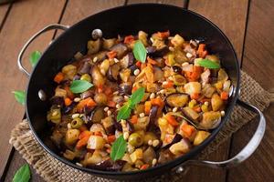 Caponata italienne avec poêle à frire sur un fond de bois photo