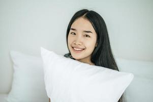 une femme assise avec un oreiller blanc photo