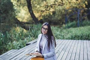 femme avec des lunettes en train de lire une livre photo