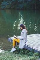 femme dans manteau en train de lire une livre photo