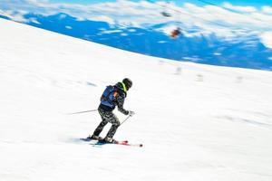 dynamique image de une skieur sur le piste dans Alpes. femme skieur dans le doux neige. actif hiver vacances, ski une descente dans ensoleillé journée. intentionnel brouiller filtre effet photo