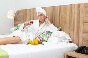 content femme en mangeant des fruits sur lit photo