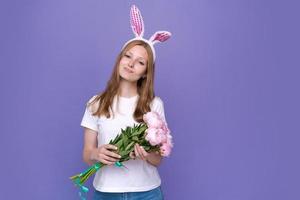 Pâques. heureuse jolie femme en oreilles de lapin de Pâques rose et t-shirt blanc photo