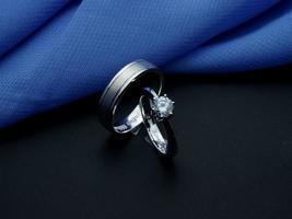 alliance en or blanc. bague couple avec finition brillante et doff avec fond bleu et noir photo