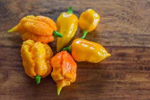 beaucoup Jaune très tranchant Habaneros sur une en bois table détail photo