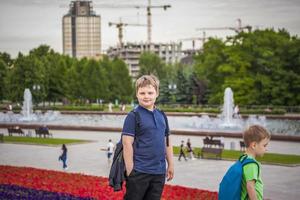 portrait d'un enfant, d'un garçon sur fond de paysages urbains de gratte-ciel et d'immeubles de grande hauteur en plein air. enfants, voyages. mode de vie dans la ville. centre, rues. photo