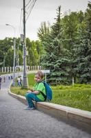 portrait d'un enfant, d'un garçon sur fond de paysages urbains de gratte-ciel et d'immeubles de grande hauteur en plein air. enfants, voyages. mode de vie dans la ville. centre, rues. photo