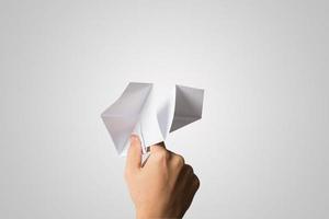 main de femme tenant un avion en papier isolé sur fond blanc photo