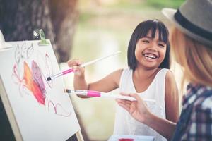 mère et fille dessiner une image ensemble dans le parc photo