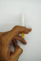 filtre cigarettes sur main et blanc Contexte. photo