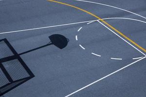 ombre de cerceau de basket-ball de rue sur le terrain de sport photo