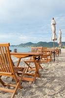 Chaises et tables sur la plage en Thaïlande photo