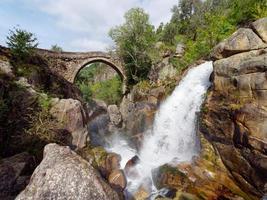 ponte da misarela ou pont de mizarela à montalegre, portugal avec une grande cascade à côté pendant une journée ensoleillée. voyages ruraux et vacances dans la nature. photo