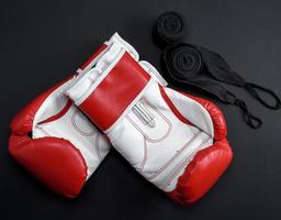 paire de rouge cuir boxe gants et une noir textile bandage photo