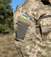 fragment de le main de une ukrainien soldat dans militaire camouflage uniforme photo