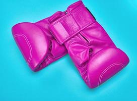 paire de rose cuir boxe gants sur une bleu Contexte photo