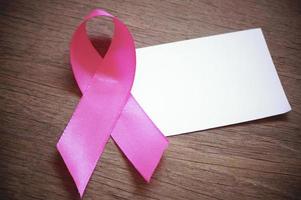 cancer du sein ruban rose avec du papier vide blanc sur fond de bois