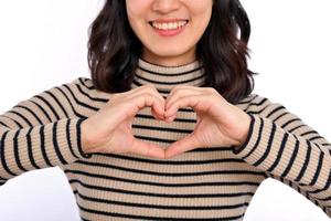 Jeune asiatique femme mains fabrication une cœur forme sur une blanc isolé Contexte photo