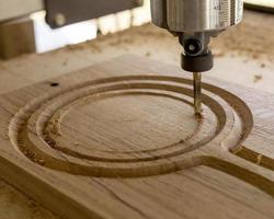 une cnc machine routage une cercle sur un chêne bois planche photo