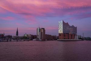 une coloré le coucher du soleil de Hambourg front de mer dans nord Allemagne avec le iconique elbphilharmonie bâtiment dans de face photo